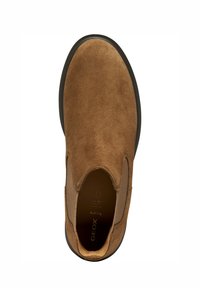 Chaussure en suède marron à enfiler avec un bout rond, des panneaux élastiques sur les côtés et une semelle en caoutchouc noire. Présente un logo imprimé sur la semelle intérieure.
