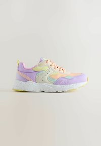 Baskets aux couleurs pastel avec des panneaux pêche, lavande, menthe et jaune, semelle blanche tachetée et lacets sur un fond clair.