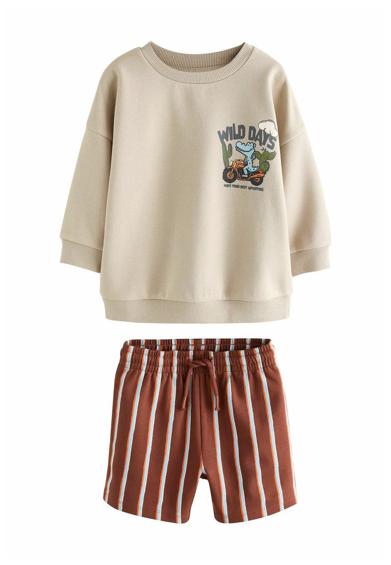 Smėlinis džemperis su animacinio stiliaus grafika ir fraze „WILD DAYS“. Komplektuojama su rudu dryžuotomis šortais su elastiniu juosmeniu.