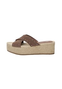 Sandali platform in suede marrone con cinturini incrociati, impreziositi da borchie in argento, dotati di una suola a cuneo in juta texture e base in gomma.