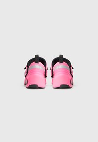 Pantofi sport roz cu un exterior neted din cauciuc, accente negre și curele ajustabile. Spate amortizat pentru confort și stabilitate.