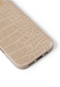 Beige phone case with a textured croc pattern, smooth surface, rounded edges, and cutouts for ports. Soft material with natural sheen.