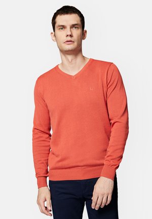 Sweter z długim rękawem w kolorze koralowo-pomarańczowym z dekoltem w kształcie litery V, wykonany z lekkiego materiału. Posiada ściągacze na rękawach i dolnym wykończeniu oraz małe logo na piersi.