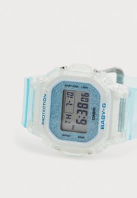 Montre numérique en résine transparente avec des accents bleus, cadran octogonal, fond bleu pailleté, affichant l'heure et la date, avec des boutons sur le côté.