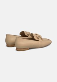 Beige leren platte schoenen met een ronde neus, voorzien van een brede band met gouden hardware accenten en een lage houten zool.