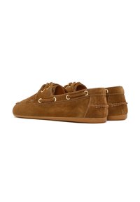 Bruine suède schoenen met een zachte textuur, voorzien van ronde veters, gouden veterogen en een flexibele rubberen zool. Minimalistische stiksels accentueren het ontwerp.