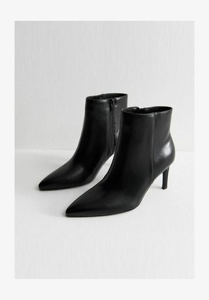 Schwarze Leder-Stiefeletten mit spitzen Zehen und einem eleganten Design. Verfügt über einen seitlichen Reißverschluss und schlanke Stiletto-Absätze für zusätzlichen Schwung.