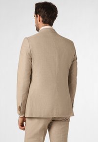Beige maatpak met een gestructureerde silhouet. Heeft een notch revers, textielstructuur en bruine knoopaccenten op de mouwen.
