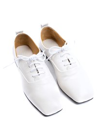 Scarpe in pelle bianca con punta squadrata arrotondata, caratterizzate da una singola cucitura e design con lacci. L'interno ha una fodera color tannato. La suola è nera.