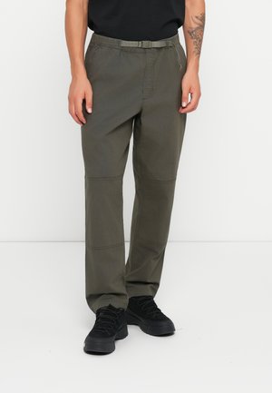 Olive green pants with a belted, elastic waistband, featuring knee patches and a relaxed fit. Paired with black lace-up shoes.