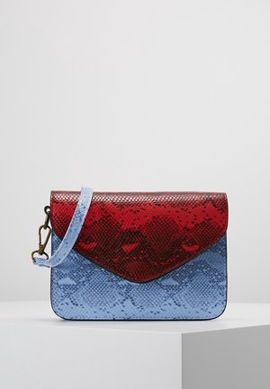 Kleine handtas met blauw en rood slangenhuidpatroon, rechthoekige vorm en afneembare blauwe band op een wit voetstuk.