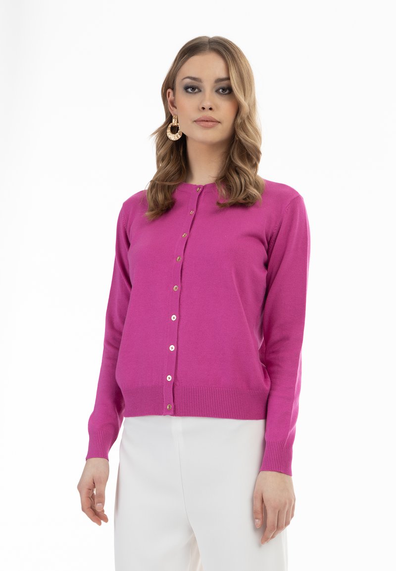 Cardigan fucsia realizzato in materiale morbido con scollo rotondo, maniche lunghe e bottoni dorati. L'orlo a coste aggiunge texture e dettaglio.