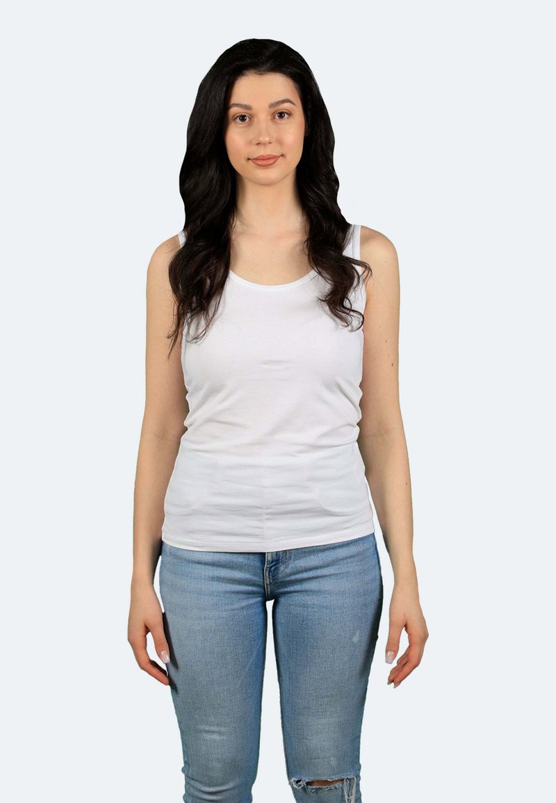 Weißes Tanktop aus weichem Stoff mit runder Ausschnittlinie, kombiniert mit hellblauen, kaputten Jeans in Knöchellänge.