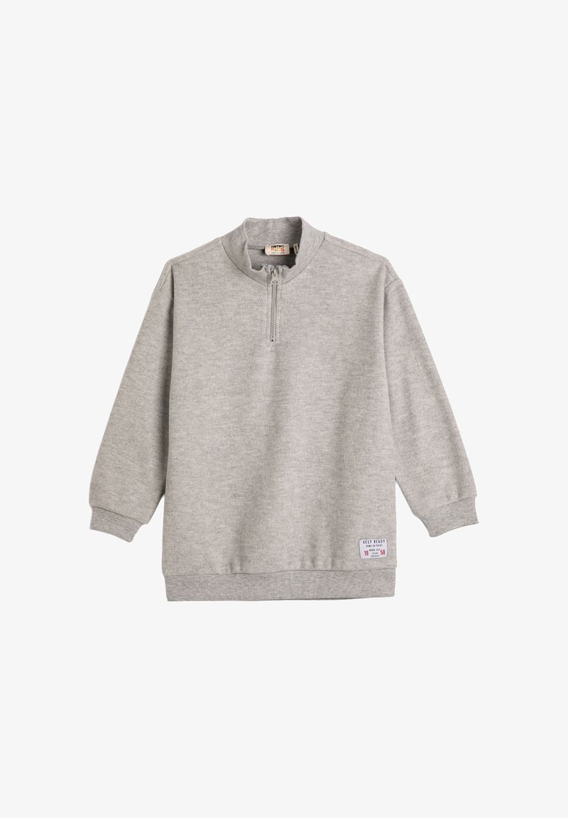 Sudadera gris claro con un cuello de media cremallera, puños y dobladillo de canalé. Presenta una pequeña etiqueta en la parte inferior derecha. Fabricada con tejido suave.