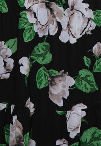 Tecido preto com grandes padrões florais brancos e beges, acentuados por folhas verdes. O design apresenta texturas suaves e um estilo em camadas.