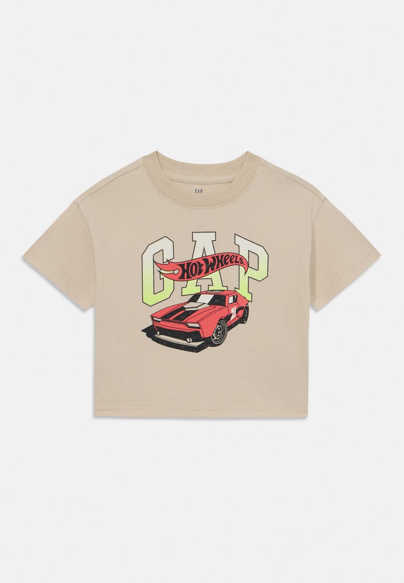 Beige cropped t-shirt med "CAP" og et grafisk motiv af en rød sportsvogn, med sorte racestreger og et "Hot Wheels" banner i kraftige farver.