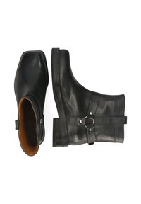Botas de cuero negras hasta el tobillo con punta cuadrada, acabado texturizado y detalle de correa lateral con acentos metálicos. Suela de goma para tracción.