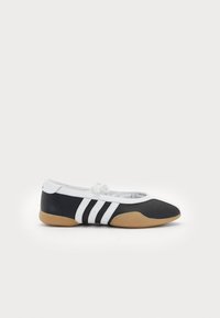 Black and white athletic shoe with a flat sole, smooth leather upper, rounded toe, and three white stripes on the side.