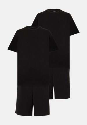 Δύο σετ απλά μαύρα κοντομάνικα μπλουζάκια με στρογγυλή λαιμόκοψη και μαύρα σορτς μέχρι το γόνατο σε φωτεινό φόντο.