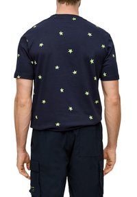 Granatowa bawełniana koszulka z rozsianym zielonym haftem kwiatowym; krótkie rękawy i okrągły dekolt. Miękka tekstura, luźny krój.