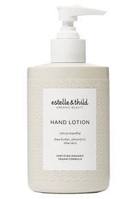 Håndlotion i en beige flaske med pumpetopp. Teksturert design med et bladmønster. Etiketten angir sitrus-mynte duft og vegansk formel.