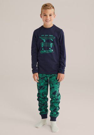 Langsleeve marineblauw shirt met groen skateboardgraphic; groene joggerbroeken met patroon en elastische boorden; katoenen materiaal, relaxed fit.