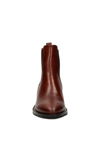 Botte chelsea en cuir marron avec des panneaux latéraux élastiques, bout arrondi et semelle noire plate. Texture lisse avec des détails de couture minimaux.