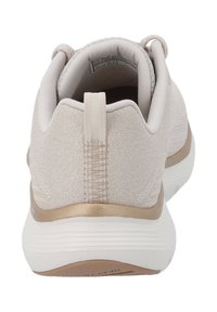 Scarpa da ginnastica beige chiaro con tomaia in tessuto texture, una banda di accentuazione dorata e una suola bianca scanalata. Linguetta sul tallone per una facile calzata.