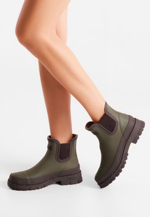 Bottes de cheville imperméables vertes avec panneaux latéraux élastiques, semelles en caoutchouc texturé et finition durable pour une adhérence et un confort optimal.