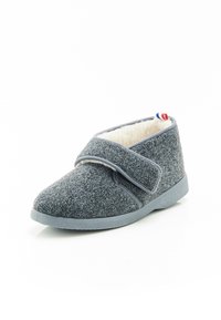 Grijze gevoerde slipper met klittenbandsluiting, zachte voering, ronde neus, en platte rubberen zool; beschikt over een klein rood, wit en blauw accent.