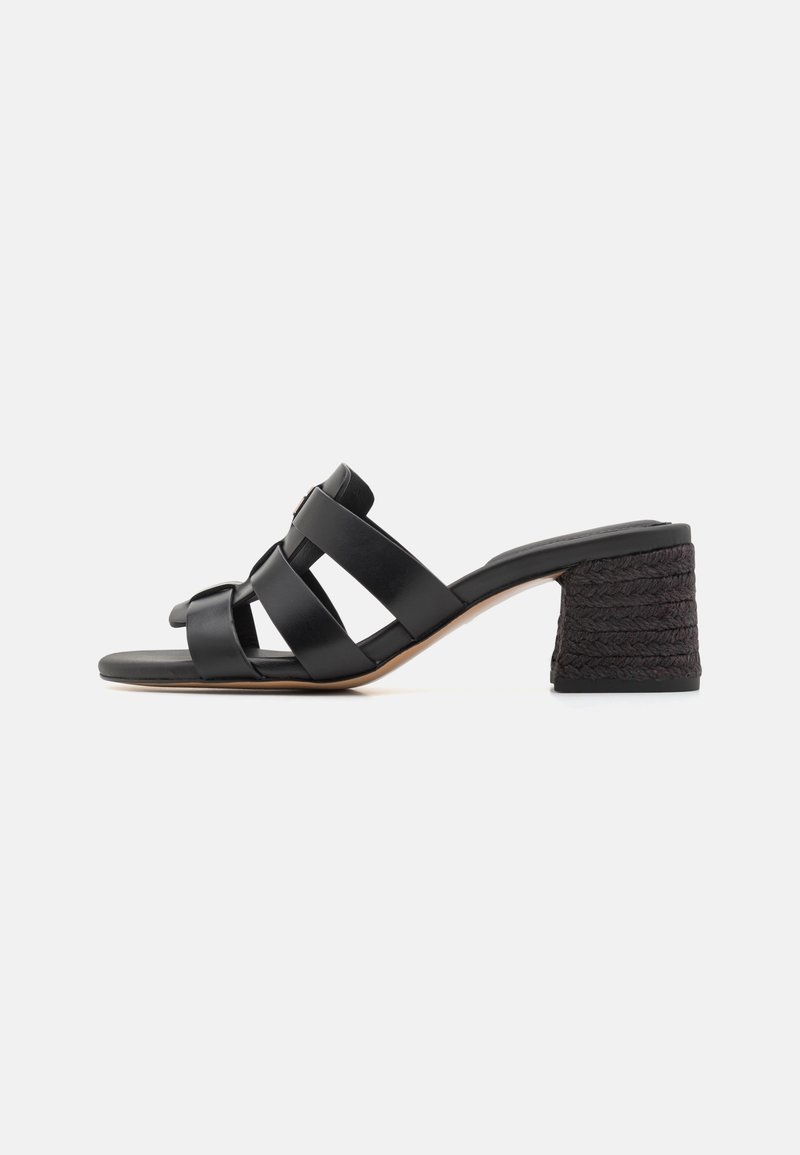 Sandale noire à talon avec de larges brides en cuir croisées sur le pied et un talon bloc texturé, vue de profil.