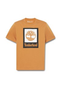 Camiseta de algodón naranja de manga corta que presenta un cuadrado blanco central con un logotipo de un árbol marrón y el texto "Timberland" en negro debajo.