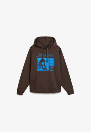 Sudadera marrón con un bolsillo delantero, que presenta un diseño gráfico azul con motivos de calaveras y mariposas, y texto en una fuente estilizada.