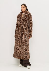 Bata de pelaje sintético con estampado de leopardo, de mangas largas, cuello ancho, cinturón en la cintura y diseño hasta las rodillas. Textura suave, en una combinación de colores marrón y negro.