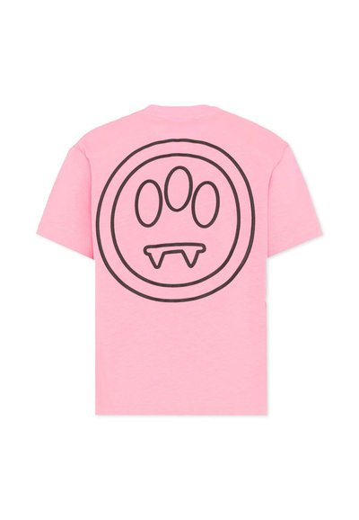 Różowy t-shirt z krótkim rękawem z dużym czarnym okrągłym wzorem na plecach, zawierającym trzy owalne kształty i element przypominający kieł wewnątrz.