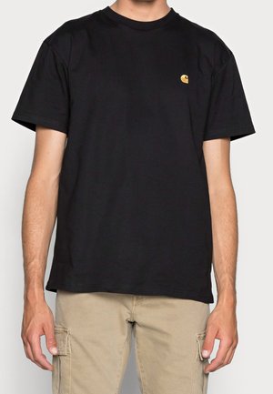 Czarny bawełniany t-shirt z krótkimi rękawami, okrągłym dekoltem, z małym żółtym logo na lewej stronie klatki piersiowej. Prosty dół.