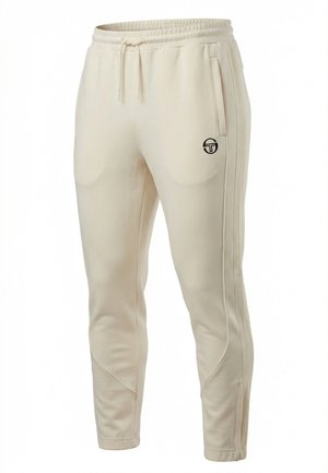 Pantaloni sportivi color beige con taglio a sigaretta, vita elastica, coulisse, tasche laterali, strisce laterali dalla texture e piccolo logo nero sulla coscia sinistra.