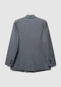 Blazer grigio su misura in tessuto strutturato, con rever a lancia, spacco singolo e tre bottoni neri come dettagli su ogni manica.