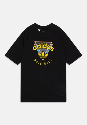 T-shirt noir à manches courtes avec un logo coloré Adidas Originals comprenant un trèfle jaune et des formes géométriques audacieuses sur le devant.