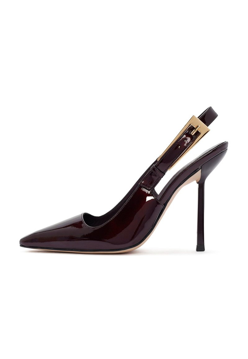 Zapato de tacón tipo slingback en burdeos, patentado, con punta afilada, acabado brillante, tacón delgado y acento dorado en la correa.
