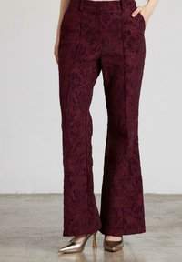 Pantalones acampanados burdeos elaborados con tejido texturizado y un patrón floral. Presentan bolsillos laterales y una cinturilla suave.