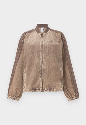 Beežides ja pruunides toonides sametbombers, millel on tõmblukuga kinnis, soonikkoes varrukasäärised ja küljetaskud, varrukatel vertikaalsed triibud.