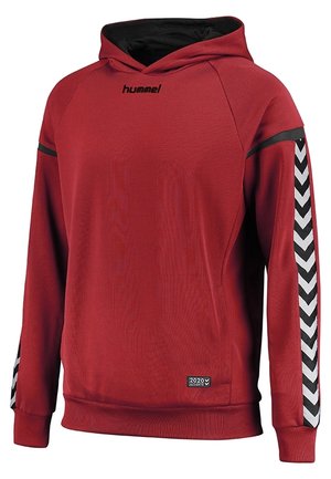 Rød hættetrøje lavet af glat stof, med sorte accentlinjer og karakteristiske sorte og hvide chevronmønstre på ærmerne.