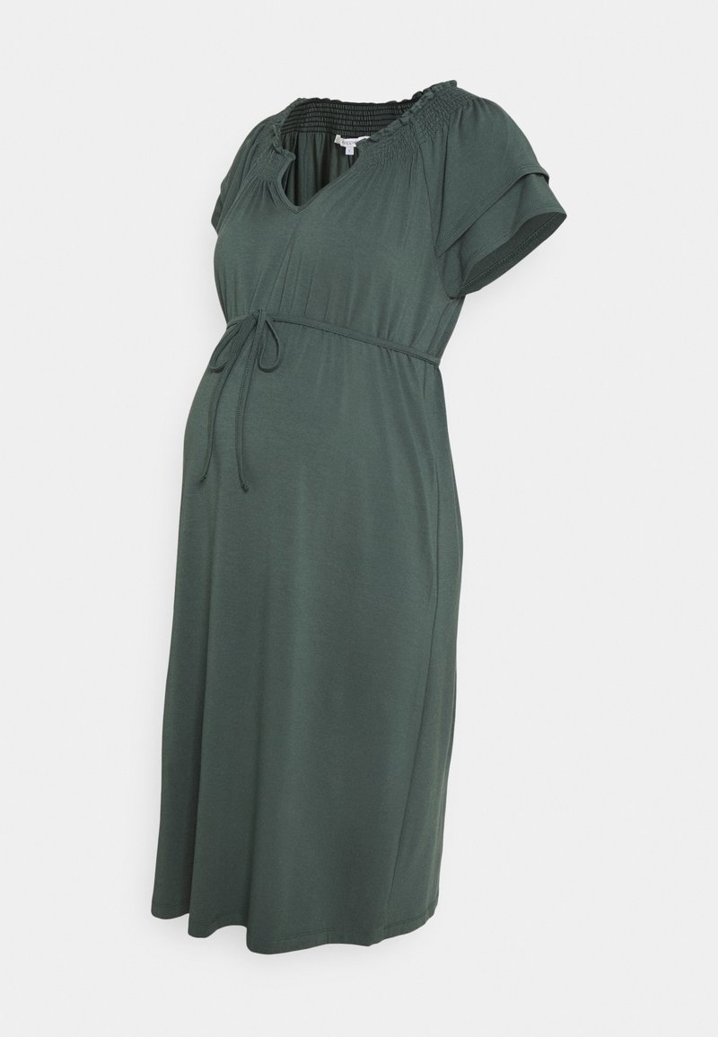Robe de maternité de couleur vert foncé, dotée de manches courtes bouffantes, d'un col smocké et d'une taille à cordon de serrage pour un ajustement facile. Texture de tissu douce.