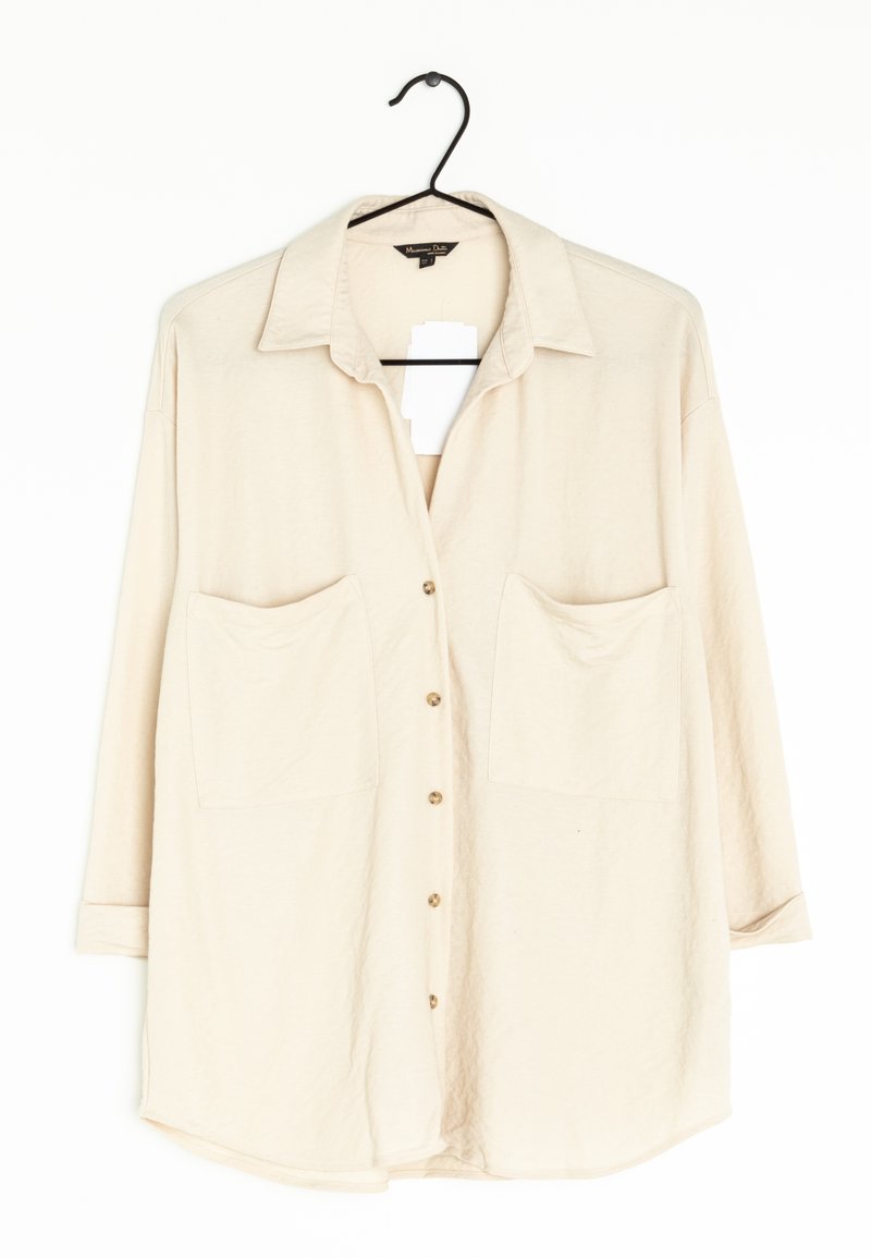 Beige kauluspaita, jossa on kaksi etutaskua ja kolmanneksen mittaiset hihat, valmistettu pehmeästä, tekstuuripinnoitteisesta kankaasta.