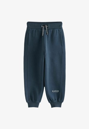 Jūras spēku sporta bikses, izgatavotas no mīksta materiāla, ar elastīgu jostasvietu ar auklu, sānu kabatām un ribotām aprocēm. Izstādīts zīmola logo.