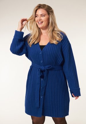 Blauwe geribde cardigan met een V-hals, knoopsluiting aan de voorkant, lange mouwen en een strikceintuur in de taille. Gebreide textuur met een zachte afwerking.