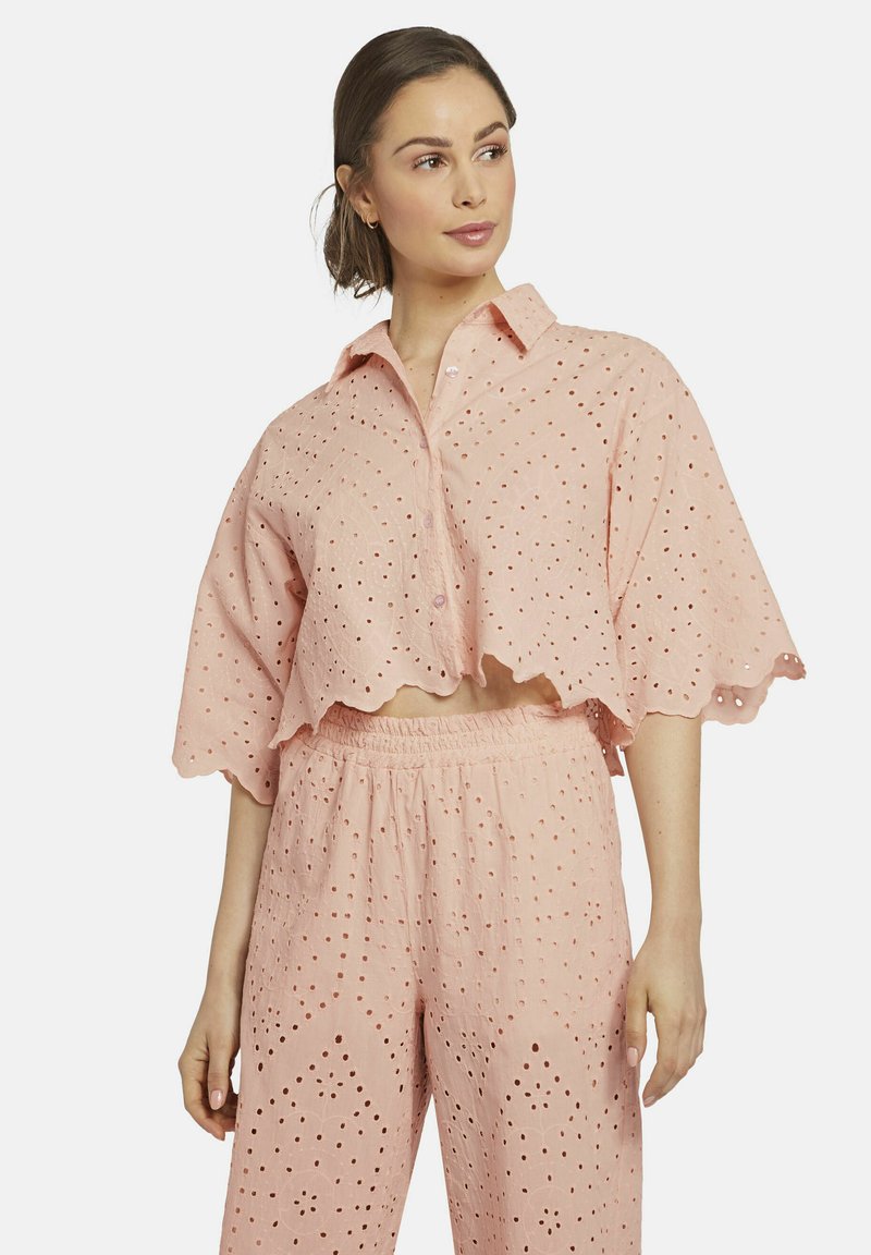 Light pink cotton two-piece outfit featuring a cropped, wave-edged shirt with eyelet detailing and loose-fitting pants with matching patterns.