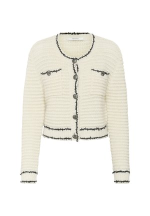 White knitted cardigan with a cropped design, black trim, and two front pockets. Features large silver buttons along the front.