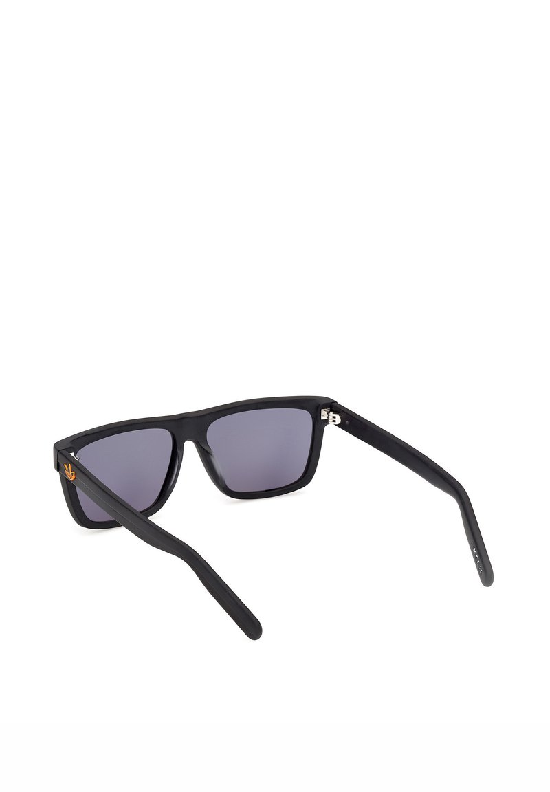 Gafas de sol rectangulares negras con lentes de tinte oscuro y un pequeño logotipo dorado en la patilla izquierda, vistas desde un ángulo trasero.